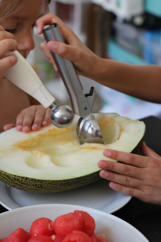niños colaborando en la cocina, bowl de frutas