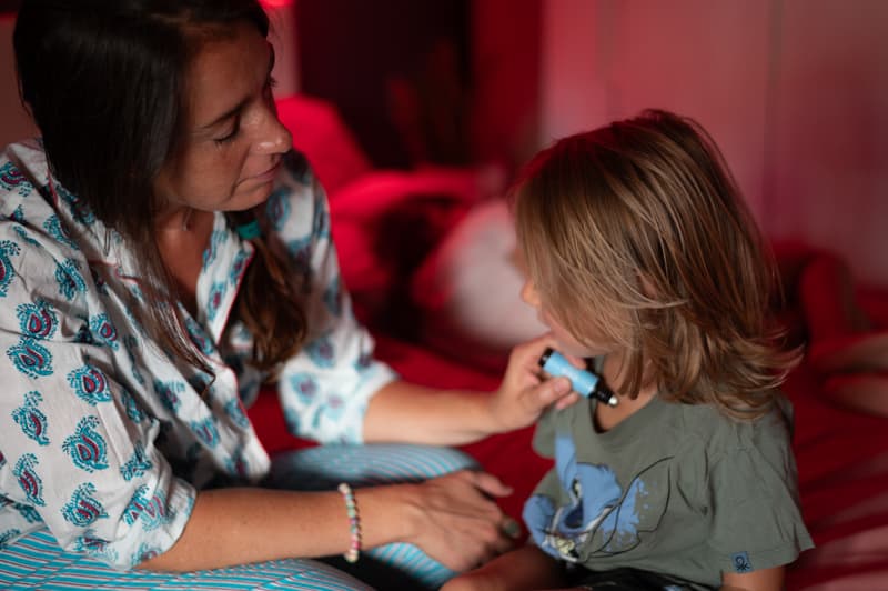 madre aplicando aceites esenciales a su hijo